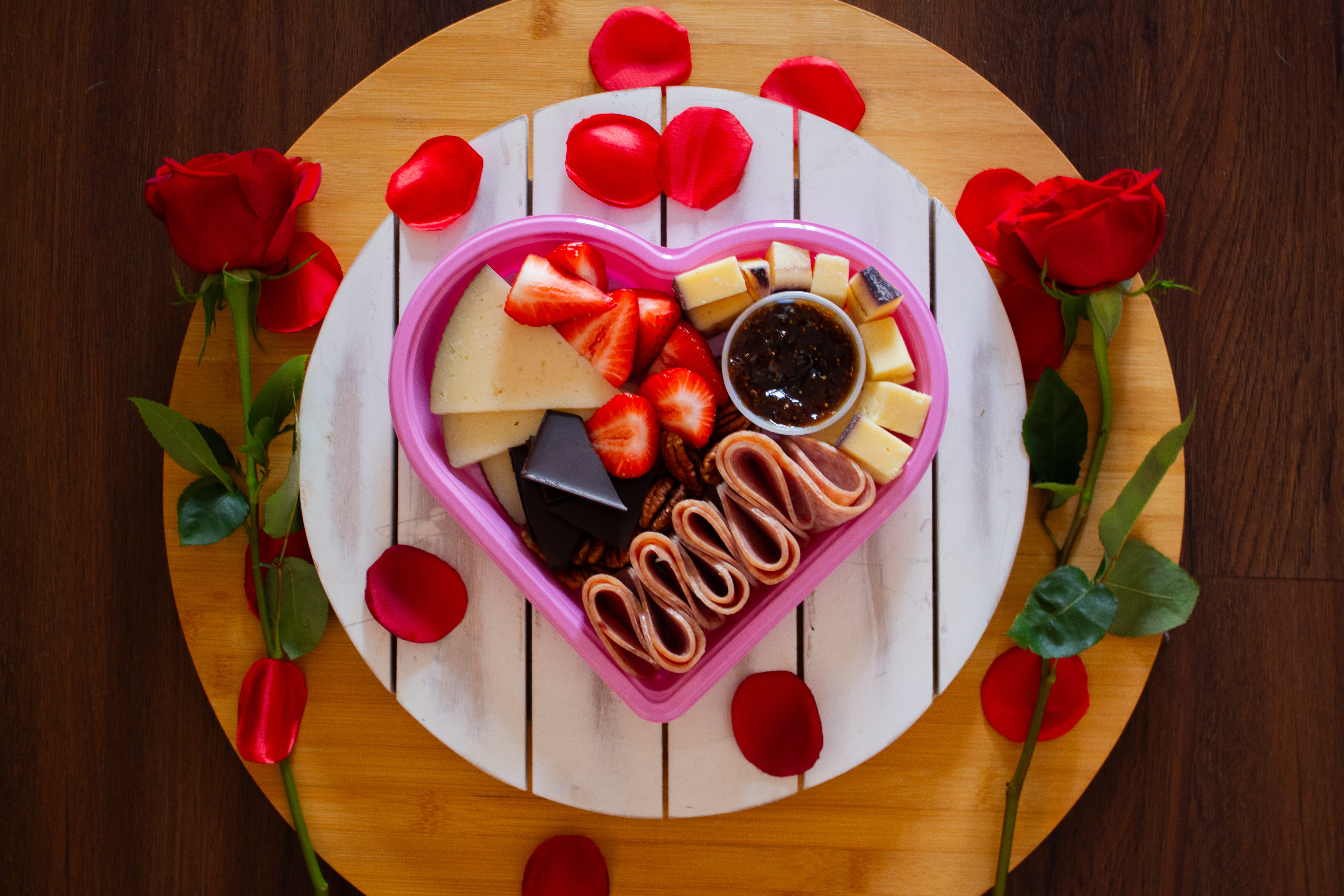Heart-shaped Valentine’s graze board with cheeses, strawberries, charcuterie, and jam